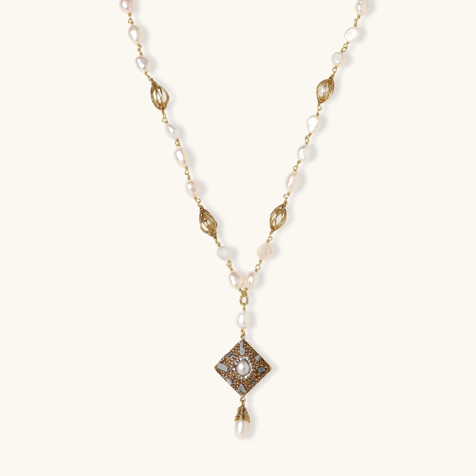 Y-shaped necklace with freshwater pearls, gold filigree stations, and ornate diamond-shaped centerpiece with pearl drop